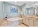 Luxurious bathroom featuring a soaking tub, neutral tile, and modern fixtures at 130 Riviera Dunes Way # 502, Palmetto, FL 34221