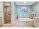 Luxurious bathroom featuring a soaking tub, neutral tile, glass shower, and modern fixtures at 130 Riviera Dunes Way # 502, Palmetto, FL 34221