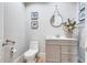 Elegant half bathroom with modern fixtures, decorative seashell art, and a stylish vanity cabinet at 130 Riviera Dunes Way # 502, Palmetto, FL 34221