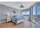 Relaxing bedroom with a ceiling fan, and expansive windows offering a picturesque water view at 130 Riviera Dunes Way # 502, Palmetto, FL 34221