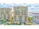 Exterior view of high-rise residential buildings with balconies, with a boat filled harbor in the background at 130 Riviera Dunes Way # 502, Palmetto, FL 34221