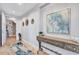 Modern condo hallway with tile flooring, a decorative table, and contemporary artwork at 130 Riviera Dunes Way # 502, Palmetto, FL 34221