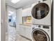 Convenient laundry area with stacked washer and dryer, complemented by white cabinetry at 130 Riviera Dunes Way # 502, Palmetto, FL 34221