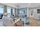 Bright living room featuring stylish furniture, a ceiling fan, water view access, and blue accent wall at 130 Riviera Dunes Way # 502, Palmetto, FL 34221