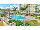Well-maintained community pool area with palm trees, ample seating and spa at 130 Riviera Dunes Way # 502, Palmetto, FL 34221