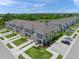 New townhome community featuring manicured landscaping, sidewalks, and ample parking near a lake and green space at 15051 Ginetti St, Nokomis, FL 34275