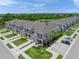 Aerial view of townhomes showcasing landscaping, parking, and proximity to community pond at 15051 Ginetti St, Nokomis, FL 34275