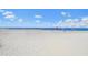 Expansive white sandy beach with scattered beachgoers enjoying the clear blue sky and calm ocean waters at 15051 Ginetti St, Nokomis, FL 34275