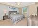 Comfortable bedroom with neutral tones, plush bedding, ceiling fan, and a window for natural light at 16804 Vardon Ter # 205, Bradenton, FL 34211