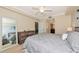 Well-lit bedroom with a ceiling fan, dresser, side table, and access to an ensuite bathroom at 16804 Vardon Ter # 205, Bradenton, FL 34211