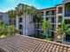 Multi-story condo building with balconies, tile roof, and tropical landscaping, perfect for relaxation at 16804 Vardon Ter # 205, Bradenton, FL 34211
