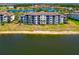 Gorgeous three-story condo building with screened balconies, lush landscaping, and beautiful lake views at 16804 Vardon Ter # 205, Bradenton, FL 34211