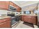 Open kitchen with stainless steel appliances, granite countertops, and hardwood cabinets at 16804 Vardon Ter # 205, Bradenton, FL 34211