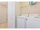 A clean and well-maintained laundry room features a washer, dryer, and wire shelving at 16804 Vardon Ter # 205, Bradenton, FL 34211