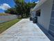 Backyard patio featuring a concrete slab with a grassy area, trash cans, and a fence at 2204 34Th W St, Bradenton, FL 34205