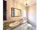 Bathroom featuring a marble countertop, white cabinets, modern lighting, and neutral paint at 2204 34Th W St, Bradenton, FL 34205