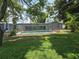 Backyard featuring a screened-in pool, mature trees, and lush green grass at 2204 34Th W St, Bradenton, FL 34205