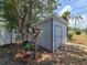 Backyard shed perfect for extra storage with double doors and surrounded by lush landscaping at 2204 34Th W St, Bradenton, FL 34205