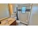 Well-lit bathroom features white and blue tile shower, cabinet, marble countertop, and a toilet at 2231 Lockwood Meadows Way, Sarasota, FL 34234