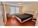 This naturally lit bedroom features hard wood floors, a queen bed, and a dresser at 2231 Lockwood Meadows Way, Sarasota, FL 34234
