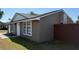 Exterior angle of home featuring white trim, black window frames, and fenced yard at 2231 Lockwood Meadows Way, Sarasota, FL 34234