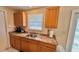 This kitchen features oak cabinets, a stainless steel sink, and natural light from a window at 2231 Lockwood Meadows Way, Sarasota, FL 34234