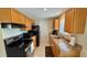 This kitchen features a range, microwave, and a sink with oak cabinets at 2231 Lockwood Meadows Way, Sarasota, FL 34234