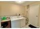 Laundry room area with washer and dryer, storage, access door, and tile flooring at 2231 Lockwood Meadows Way, Sarasota, FL 34234
