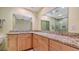 Bathroom with wooden cabinets, granite countertop, large mirrors, and a separate shower at 2259 Pueblo Ln # V38, Sarasota, FL 34231