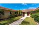 Exterior view of condo entrances with well maintained lawns and landscaping leading to the front doors at 2259 Pueblo Ln # V38, Sarasota, FL 34231