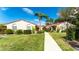 Charming single-story home featuring a well-manicured lawn, vibrant landscaping, and a welcoming walkway to the entrance at 2259 Pueblo Ln # V38, Sarasota, FL 34231