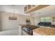 Open kitchen with an electric range oven and granite countertops, connecting to the living area at 2259 Pueblo Ln # V38, Sarasota, FL 34231