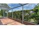 View of the tiled patio area with privacy landscaping and enclosed screen and aluminum frame at 2259 Pueblo Ln # V38, Sarasota, FL 34231