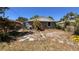Back of home view with overgrown backyard, trees, and window view at 2448 45Th S St, St Petersburg, FL 33711