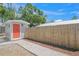 Charming backyard shed with a vibrant door and stone pathway leading to a tranquil outdoor space at 2537 Ashton Rd, Sarasota, FL 34231