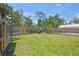 Spacious backyard offers a lush green lawn, a mature tree, and a wood fence for privacy at 2537 Ashton Rd, Sarasota, FL 34231
