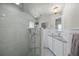 Bright bathroom features tiled walk-in shower, updated vanity, and stylish light fixtures at 2537 Ashton Rd, Sarasota, FL 34231