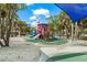 A fun playground with slides and climbing features is surrounded by lush trees and a sandy area at 2537 Ashton Rd, Sarasota, FL 34231