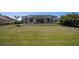 Wide shot of backyard with screen-enclosed pool and well maintained lawn at 260 Marker Rd, Rotonda West, FL 33947
