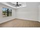 Bedroom with a decorative trey ceiling, wood-look tile floors, and large window at 260 Marker Rd, Rotonda West, FL 33947