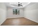 Bedroom with decorative trey ceiling, wood-look tile floors, and large window at 260 Marker Rd, Rotonda West, FL 33947