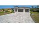 Charming two-story home featuring a brick paved driveway, two-car garage, and manicured lawn at 260 Marker Rd, Rotonda West, FL 33947