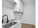 Well-lit laundry room area featuring granite countertops, shaker-style cabinets, and stainless steel sink at 260 Marker Rd, Rotonda West, FL 33947