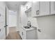 Well-lit laundry room area featuring granite countertops, shaker-style cabinets, and stainless steel sink at 260 Marker Rd, Rotonda West, FL 33947