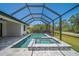 Stunning screened-in pool and jacuzzi surrounded by a beautiful view of nature at 260 Marker Rd, Rotonda West, FL 33947
