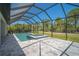 Screened-in pool and spa surrounded by lush landscaping and a spacious backyard at 260 Marker Rd, Rotonda West, FL 33947