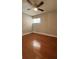 This bedroom features wood floors, a ceiling fan, and a bright window at 2763 Woodgate Ln # 210, Sarasota, FL 34231