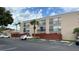 Exterior view of multi-Gathering condo with black wrought iron balconies and tan paint scheme at 2763 Woodgate Ln # 210, Sarasota, FL 34231