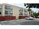 Exterior view of multi-Gathering condo with black wrought iron balconies and tan paint scheme at 2763 Woodgate Ln # 210, Sarasota, FL 34231