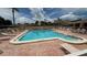 A beautiful outdoor pool with brick trim and lounge chairs around the perimeter on a sunny day at 2763 Woodgate Ln # 210, Sarasota, FL 34231
